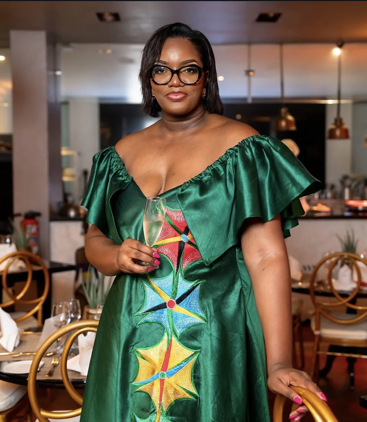 Portrait de la direction d'AllSmart en robe verte brodée, lors d'un dîner